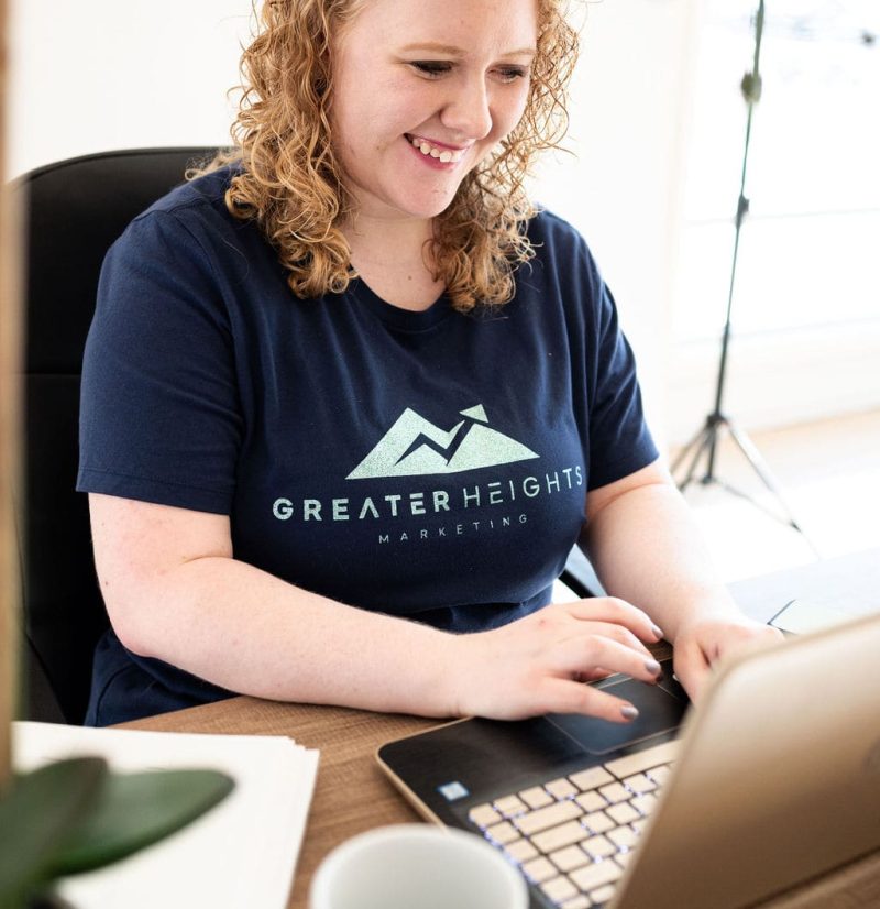 Hailey Fackrell getting web design and branding work done and smiling at computer